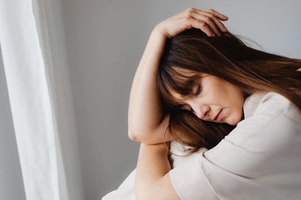 A peaceful close-up portrait of a brunette woman with closed eyes, conveying elegance and tranquility.